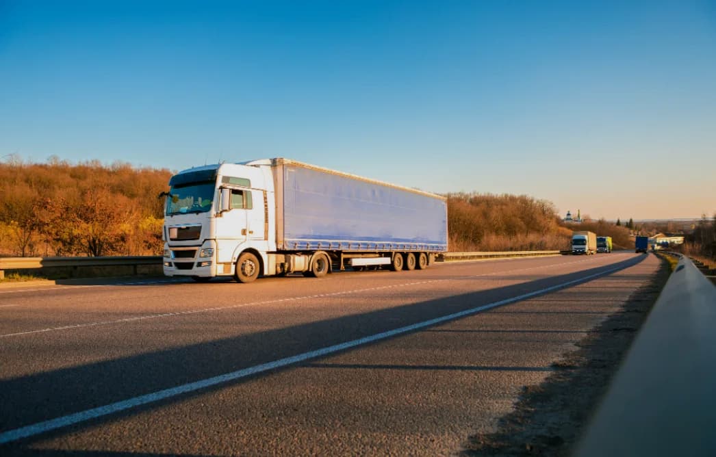A freight truck on a highway at sunset